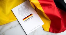 Grundgesetz-Buch der Bundesrepublik Deutschland auf Flagge. Foto: Adobe Stock | Christin Klose