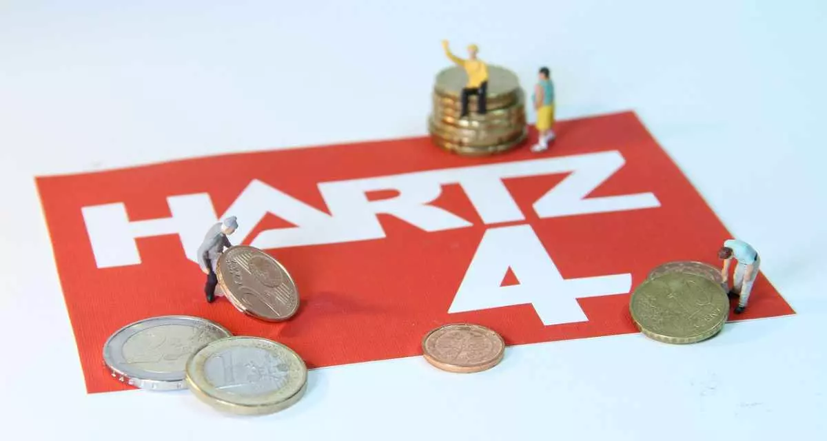 Der Schriftzug Hartz IV, darauf MÃ¼nzen und Spielfiguren.