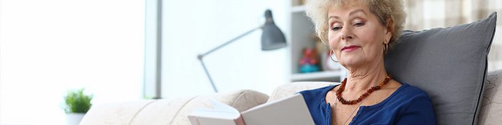 Ã„ltere Frau liest ein Buch. Foto: Adobe Stock