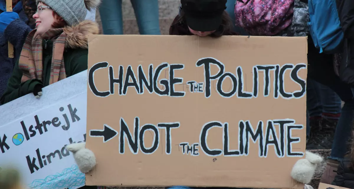 Schild bei Klimaprotest mit der Aufschrift â€žChange the Politics, not the Climateâ€œ.