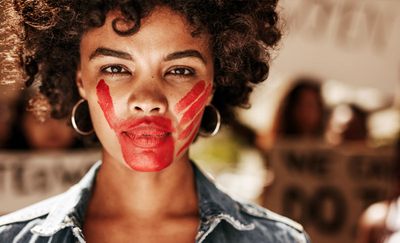 Stoppt Gewalt gegen Frauen. Foto: Frauengesicht mit roter aufgemalter Hand Ã¼ber dem Mund. Adobe Stock | Jacob Lund | 211192026