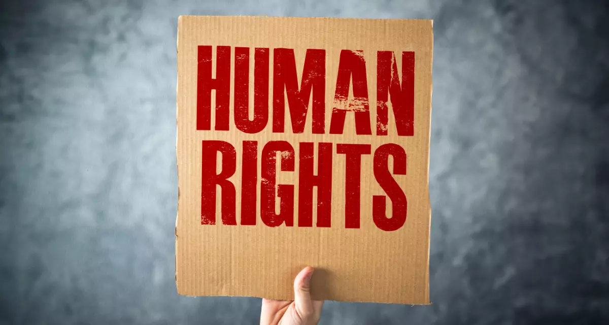 Hand hÃ¤lt Pappschild mit Aufschrift â€žHuman Rightsâ€œ.