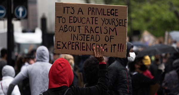 "Es ist ein Privileg, sich Ã¼ber Rassismus zu informieren, anstatt ihn zu erleben." Plakat auf einer Demonstration. Foto: Unsplash / James Eades. 