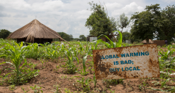Schild mit der Aufschrift „Global warming is bad, buy local“ als Unterstützung für südsudanesische Flüchtlinge in Uganda. Foto: © UNHCR/Jordi Matas Schild mit der Aufschrift „Global warming is bad, buy local“ als Unterstützung für südsudanesische Flüchtlinge in Uganda. Foto: © UNHCR/Jordi Matas