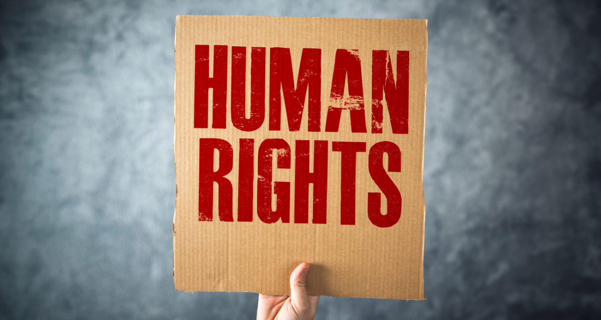 Hand hält Pappschild mit Aufschrift „Human Rights“. Foto: Adobe Stock | Bits and Splits Hand hält Pappschild mit Aufschrift „Human Rights“.